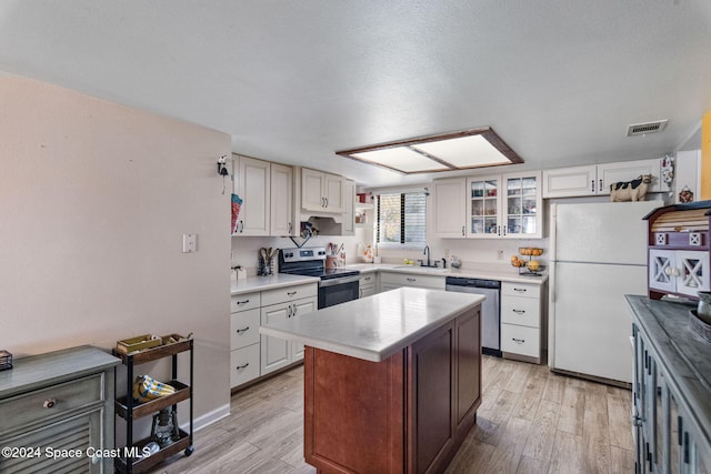 kitchen with stainless steel appliances, sink, a center island, light hardwood / wood-style floors, and white cabinetry