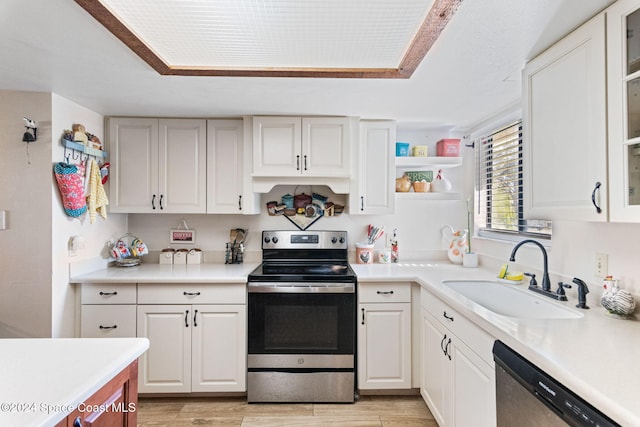 kitchen featuring appliances with stainless steel finishes, light hardwood / wood-style floors, white cabinetry, and sink