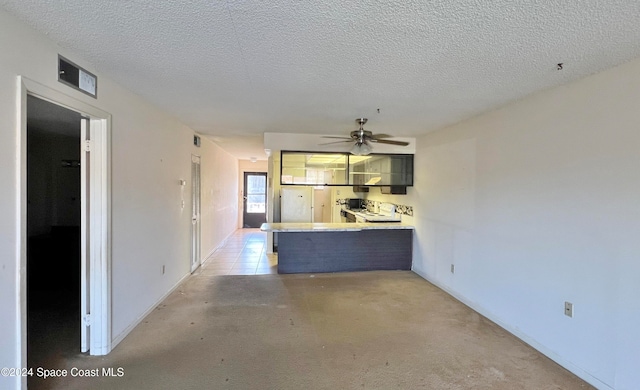 interior space featuring ceiling fan, kitchen peninsula, and a textured ceiling