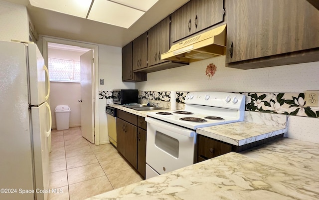 kitchen featuring dark brown cabinets, light tile patterned flooring, and appliances with stainless steel finishes