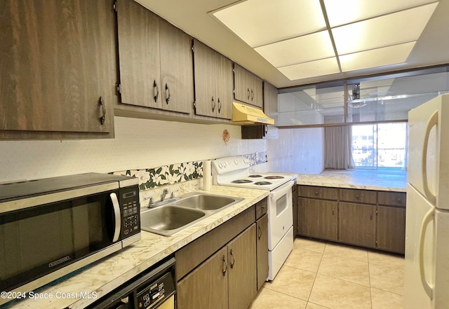 kitchen featuring sink, light tile patterned floors, and white appliances