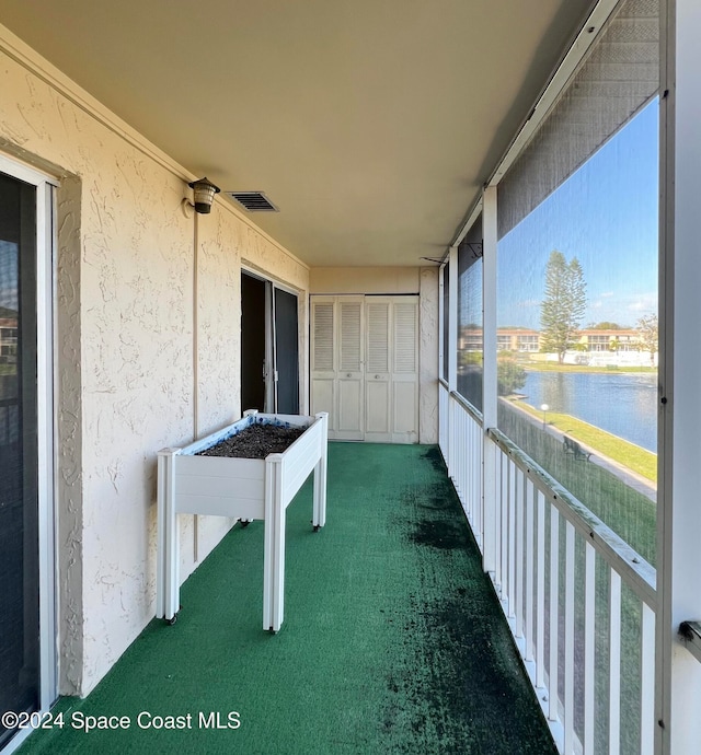 unfurnished sunroom featuring a water view