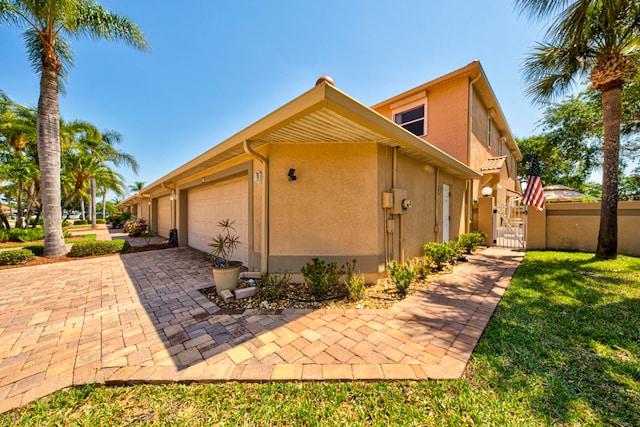 view of property exterior with a garage, fence, and stucco siding