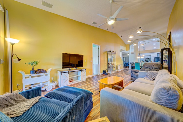 living room with ceiling fan, light hardwood / wood-style flooring, and lofted ceiling