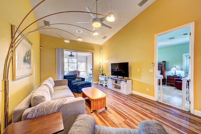 living room featuring ceiling fan, lofted ceiling, and light hardwood / wood-style flooring