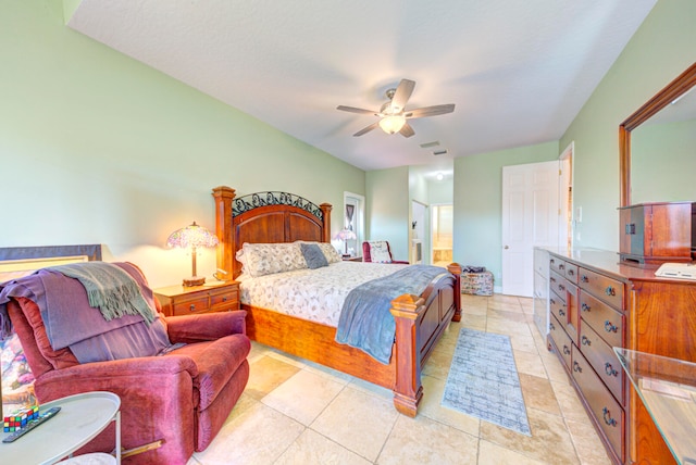 bedroom featuring ceiling fan, light tile patterned floors, and ensuite bath