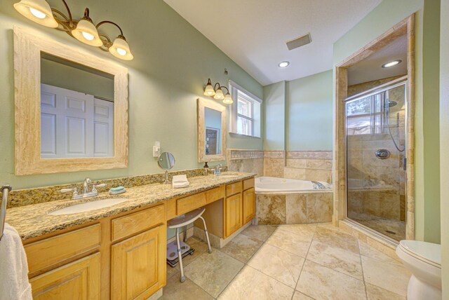 bathroom featuring a bath, a stall shower, double vanity, and toilet