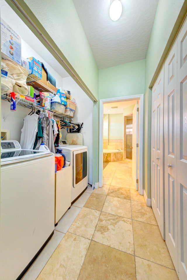 laundry area featuring light tile patterned flooring, independent washer and dryer, and a textured ceiling