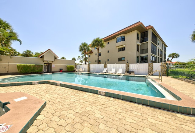 community pool featuring fence and a patio