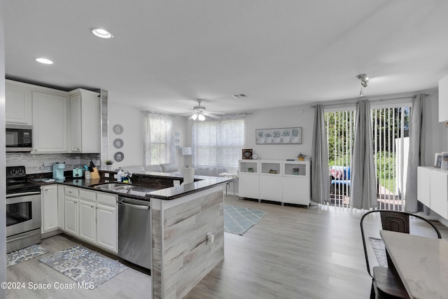 kitchen featuring ceiling fan, sink, stainless steel appliances, kitchen peninsula, and white cabinets