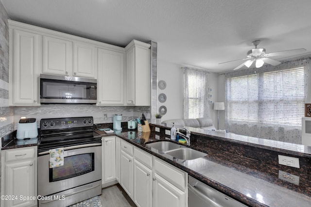 kitchen featuring stainless steel appliances, white cabinetry, ceiling fan, and sink