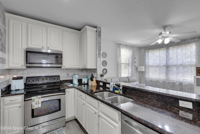 3156 Via Palma Ln, Kissimmee, FL 34744 - kitchen featuring appliances with stainless steel finishes, a sink, dark stone counters, and white cabinets