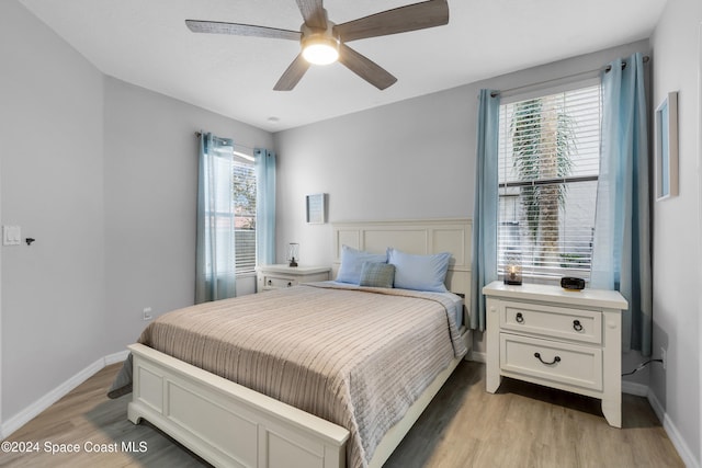 bedroom featuring multiple windows, ceiling fan, and light wood-type flooring