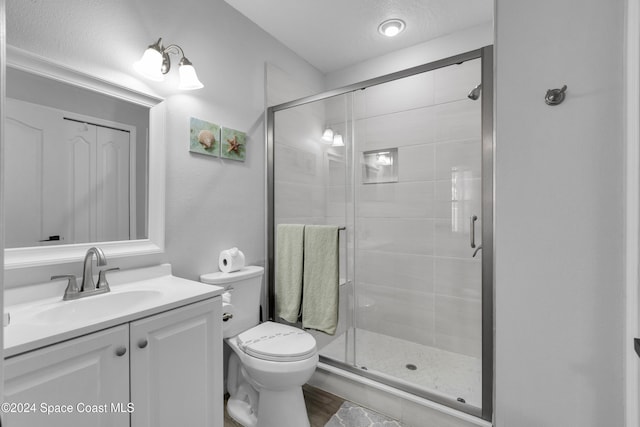 bathroom with wood-type flooring, vanity, toilet, and an enclosed shower