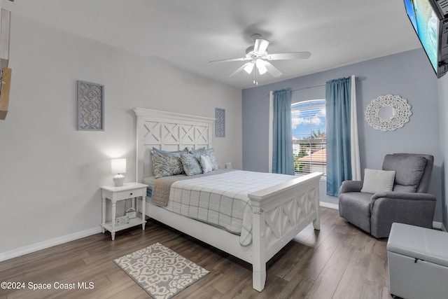 bedroom with dark hardwood / wood-style flooring and ceiling fan