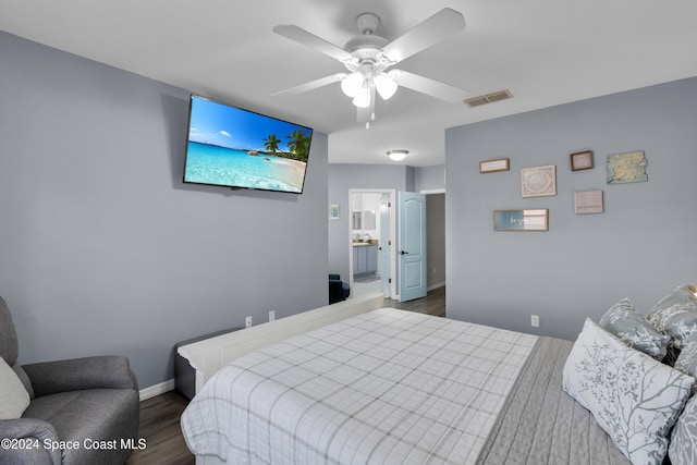 bedroom with ensuite bathroom, ceiling fan, and dark wood-type flooring