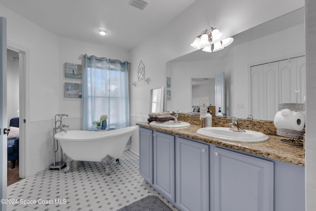 bathroom featuring tile patterned floors, a tub, and vanity