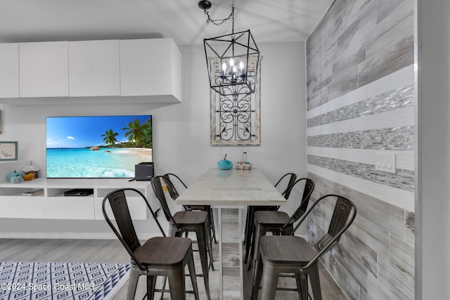 dining room with light hardwood / wood-style floors and a notable chandelier