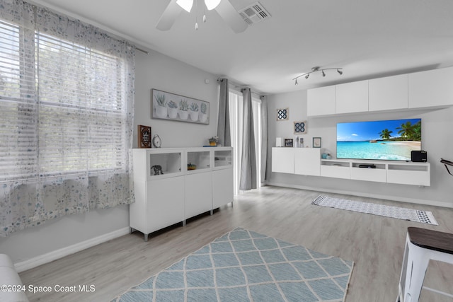 living room with light hardwood / wood-style floors, plenty of natural light, and ceiling fan