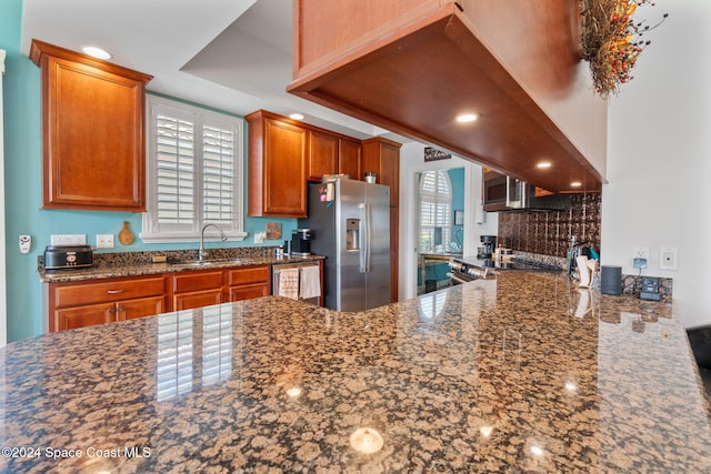 kitchen with kitchen peninsula, stainless steel appliances, a wealth of natural light, and sink