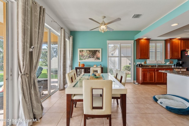 dining space featuring ceiling fan, light tile patterned floors, sink, and a wealth of natural light