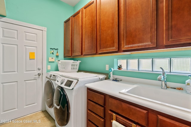 clothes washing area featuring cabinets, independent washer and dryer, sink, and light tile patterned floors