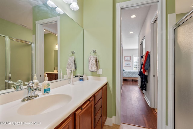 bathroom with wood-type flooring, vanity, and walk in shower