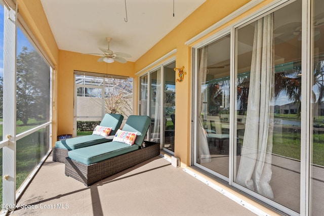 unfurnished sunroom featuring ceiling fan