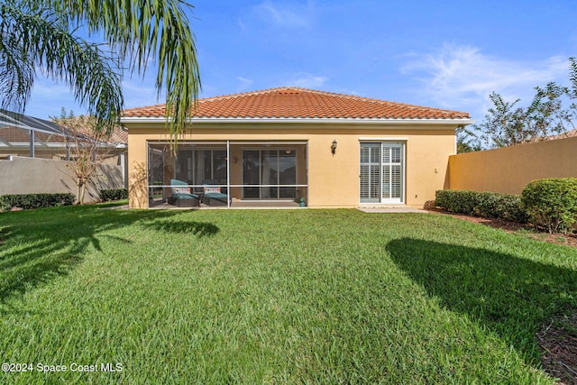 rear view of house featuring a yard