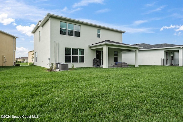 rear view of house featuring a yard and cooling unit