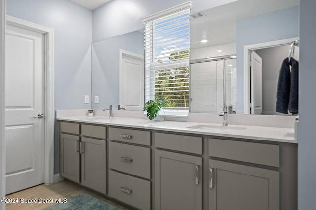 bathroom with vanity, an enclosed shower, and wood-type flooring