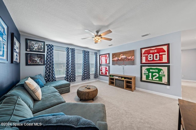 carpeted living room featuring a textured ceiling and ceiling fan