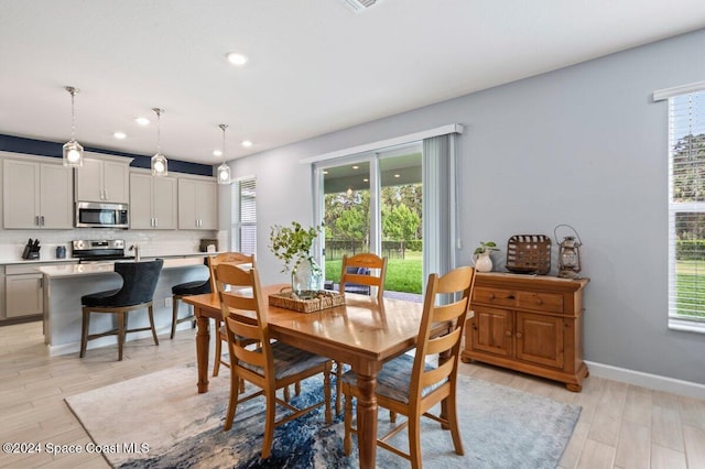 dining area featuring light wood-type flooring and plenty of natural light