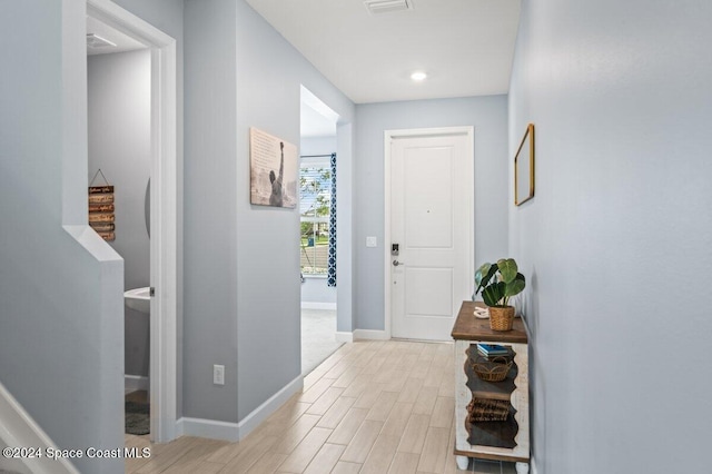 corridor with light hardwood / wood-style floors