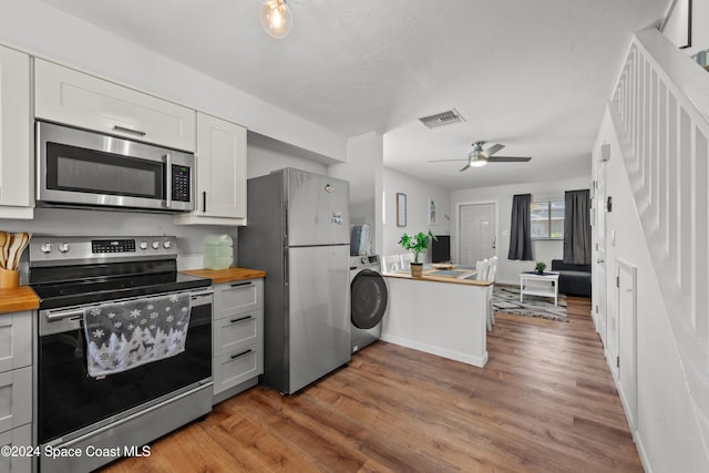 13433 Heald Ln Unit 1, Fort Myers, FL 33908 - kitchen with wooden counters, stainless steel appliances, washer / dryer, wood finished floors, and a ceiling fan