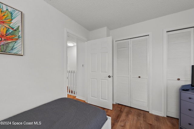 13433 Heald Ln Unit 1, Fort Myers, FL 33908 - bedroom featuring wood finished floors, multiple closets, and a textured ceiling