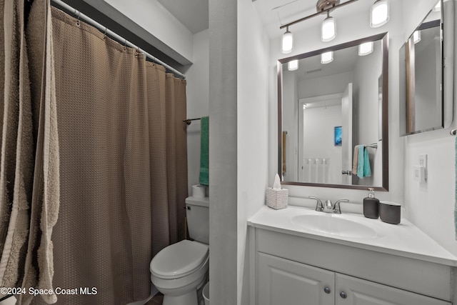 bathroom with a shower with shower curtain, vanity, and toilet