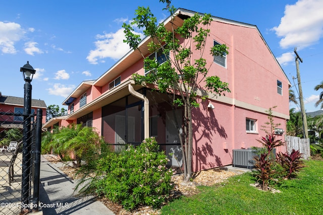 view of property exterior with a sunroom and central AC unit