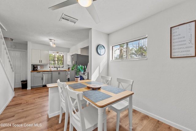 dining area featuring ceiling fan, light hardwood / wood-style floors, and sink