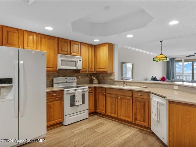 kitchen with ceiling fan, sink, light hardwood / wood-style floors, decorative light fixtures, and white appliances