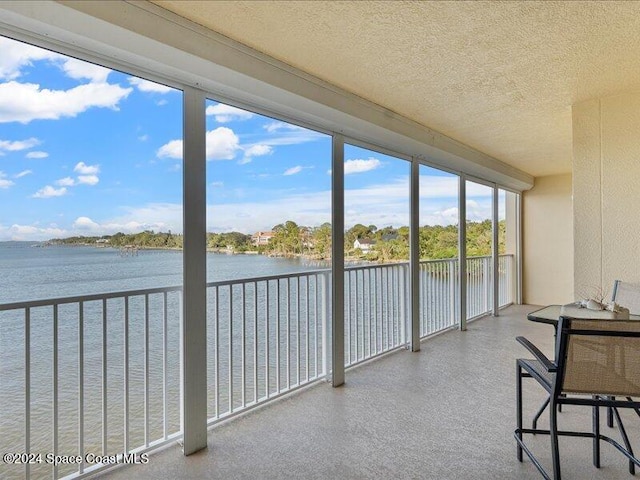 unfurnished sunroom featuring a water view