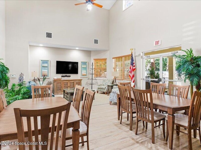 dining area featuring light hardwood / wood-style floors, high vaulted ceiling, and ceiling fan