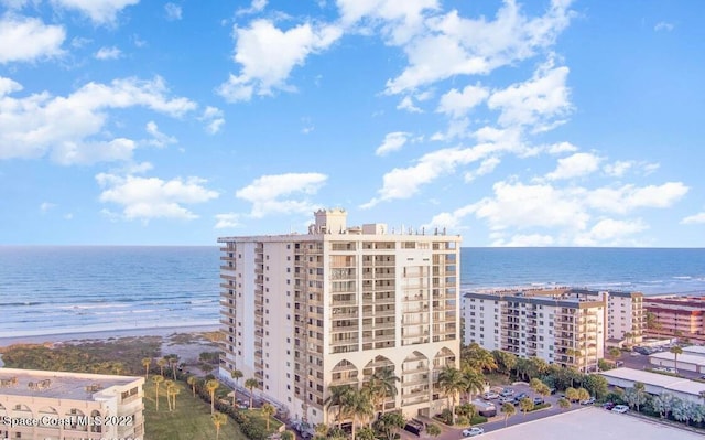 birds eye view of property featuring a water view and a beach view