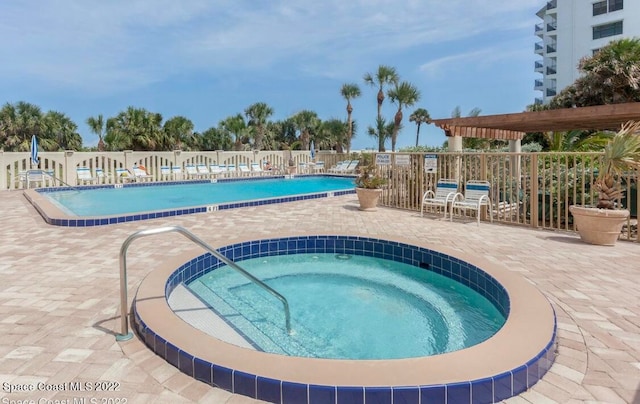 view of swimming pool featuring a pergola, a patio, and a hot tub