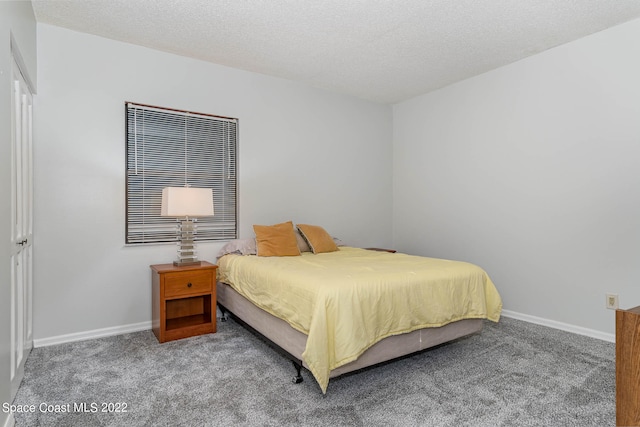 bedroom featuring carpet flooring and a textured ceiling