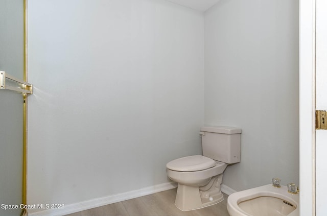 bathroom with hardwood / wood-style floors, a bidet, and toilet