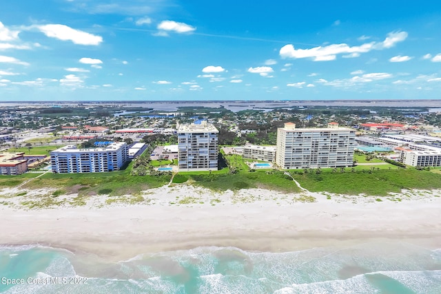 drone / aerial view featuring a water view and a view of the beach