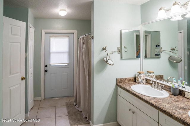 bathroom featuring tile patterned floors, vanity, and a textured ceiling