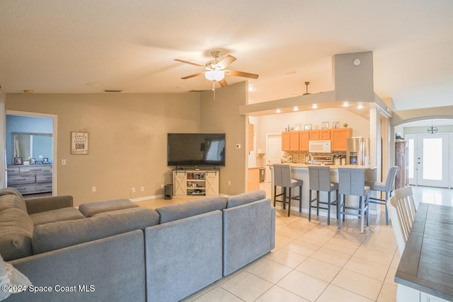 living room with light tile patterned floors, ceiling fan, and lofted ceiling