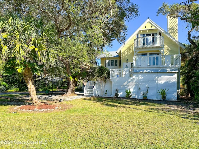 5875 Riverside Dr, Melbourne Beach, FL 32951 - back of house with a balcony, a lawn, and a chimney